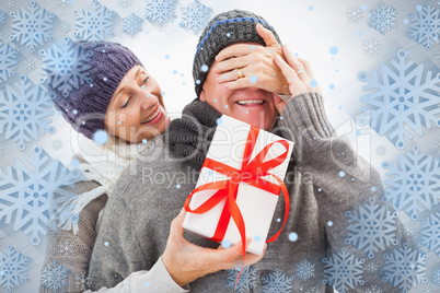 Happy mature woman hiding gift from partner