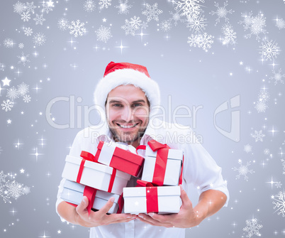 Composite image of festive man holding christmas gifts