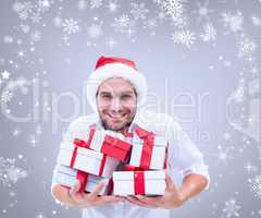 Composite image of festive man holding christmas gifts