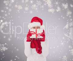 Composite image of festive woman holding gift