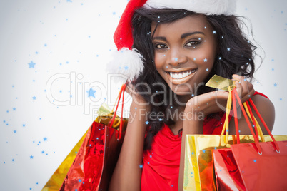 Festive woman standing looking while holding bags