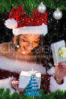 Pretty brunette in santa outfit opening gift