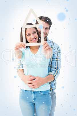 Happy young couple with house shape