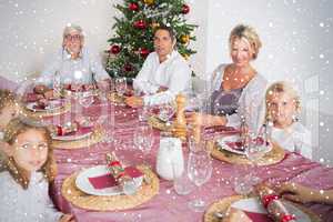 Composite image of smiling family at the dinner table