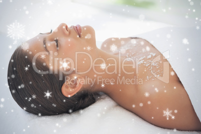 Beautiful brunette lying on massage table with salt scrub on che