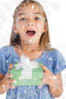 Composite image of excited little girl holding a wrapped gift