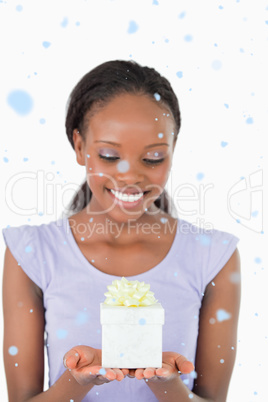Composite image of close up of woman looking at a present agains