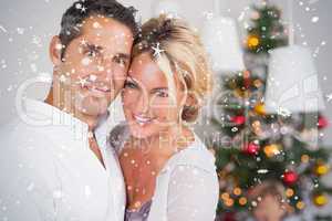 Composite image of couple embracing at christmas