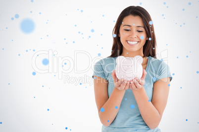 Attractive woman posing with a piggy bank
