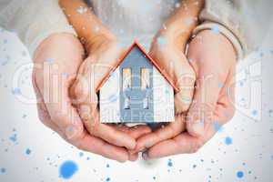 Couple holding small model house in hands