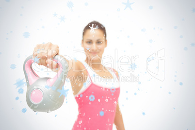 Smiling toned brunette showing grey and pink kettlebell