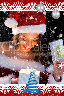 Pretty brunette in santa outfit opening gift