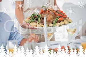 Composite image of woman brining a roast chicken in the dining r