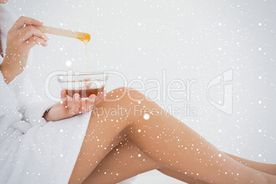 Side view of woman holding hot wax in bowl at spa center