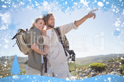 Hiking couple standing on mountain terrain looking around