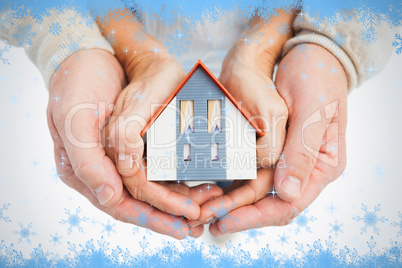 Couple holding small model house in hands