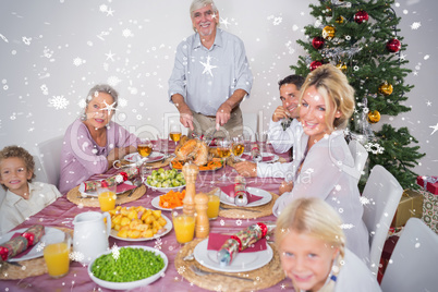 Composite image of happy family at christmas dinner