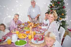 Composite image of happy family at christmas dinner