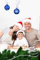 Composite image of happy family baking christmas cookies togethe