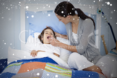 Composite image of mother taking her sons temperature with a the