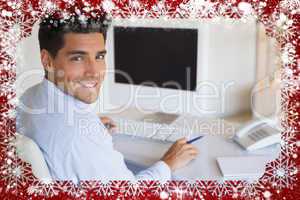 Casual businessman at desk smiling at camera