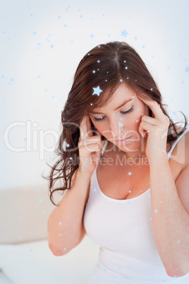 Beautiful brunette woman having a headache while sitting