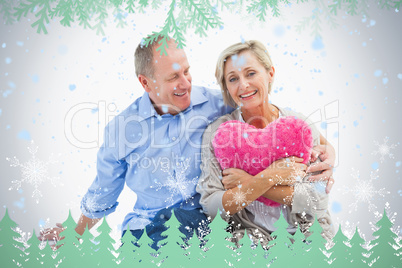 Happy mature couple with heart pillow