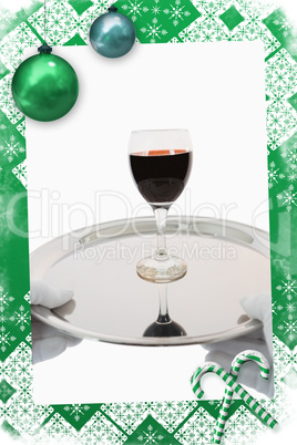 Composite image of waiter holding a glass of red wine