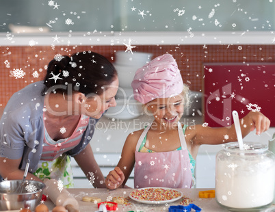 Composite image of happy mother and her daughter baking in a kit