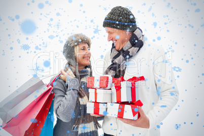 Mature couple in winter clothes holding gifts