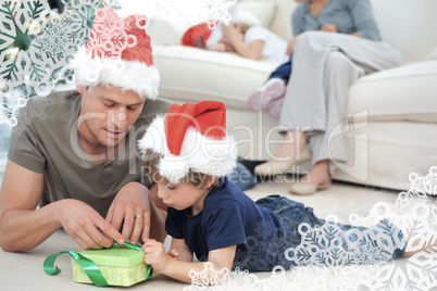 Father and son unwrapping a present lying on the floor