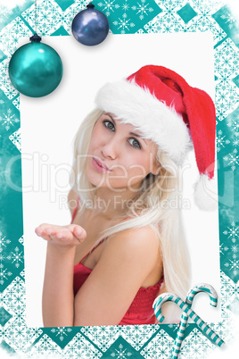 Composite image of woman wearing santa hat as she blows kiss