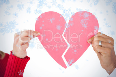 Couple holding two halves of broken heart