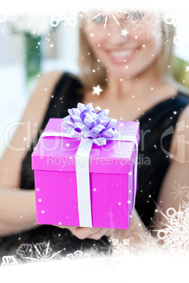 Blond woman opening a gift sitting on a sofa