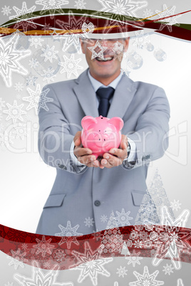 Composite image of wide smiling businessman holding piggy bank