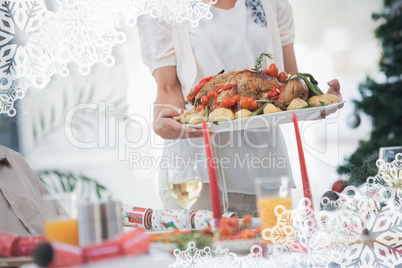 Composite image of woman bringing roast chicken at table