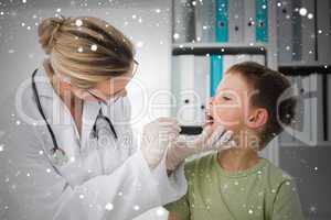 Composite image of doctor looking into the mouth of boy
