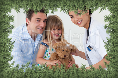 Portrait of a doctor and happy little girl examing a teddy bear