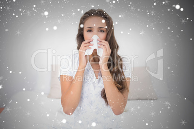 Composite image of pretty brunette blowing her nose