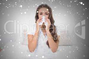 Composite image of pretty brunette blowing her nose