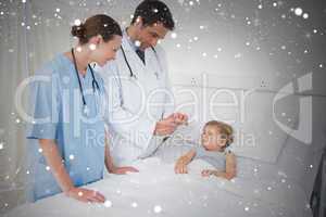 Composite image of doctors attending little girl