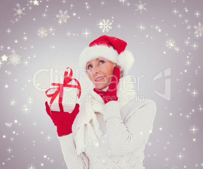 Composite image of festive woman holding gift