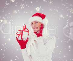 Composite image of festive woman holding gift