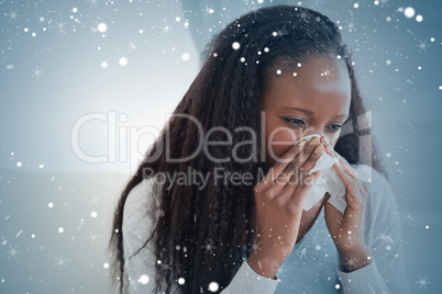 Composite image of close up of woman blowing her nose