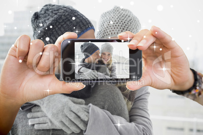 Hand holding smartphone showing photo