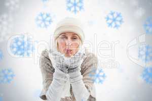 Mature woman in winter clothes blowing kiss