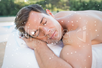 Peaceful man lying on massage table poolside