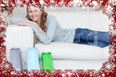 Woman relaxing on the sofa next to her shopping
