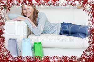 Woman relaxing on the sofa next to her shopping