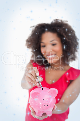 Composite image of money been put into a pink piggy bank